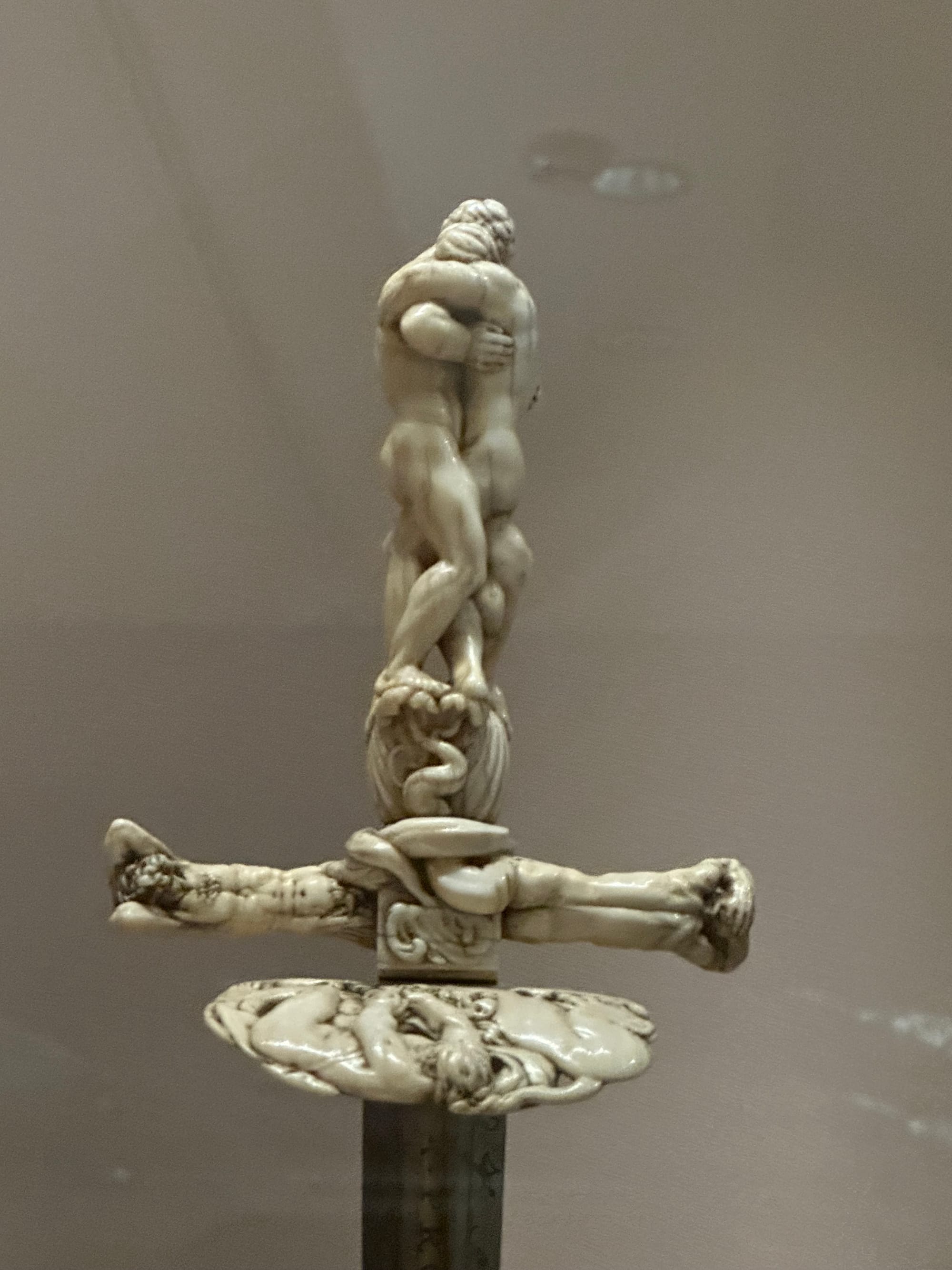Two nude men embracing form the hilt of this blade, while two more nude men form the guard